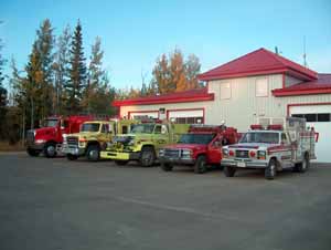 Five fire rescue vehicles parked in front of a fire department facility